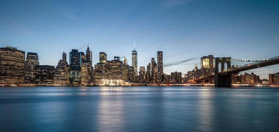 The New York City skyline, Brooklyn Bridge, and East River at dusk